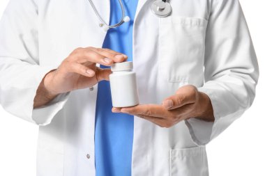 Beyaz arka planda A vitamini şişesi olan erkek doktor, yakın plan.