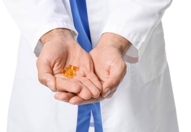 Beyaz arka planda vitaminleri olan erkek doktor, yakın plan.