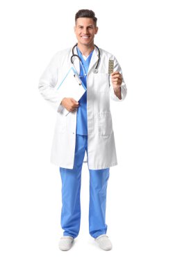 Beyaz arka planda vitaminleri ve panosu olan erkek doktor.