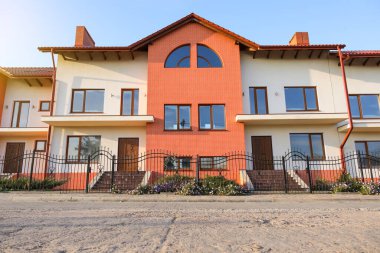 Güneşli bir günde modern kır evleri olan bir sokak.