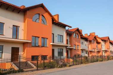 Güneşli bir günde modern kır evleri olan bir sokak.