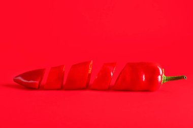 Kırmızı arkaplanda kırmızı biberi kes