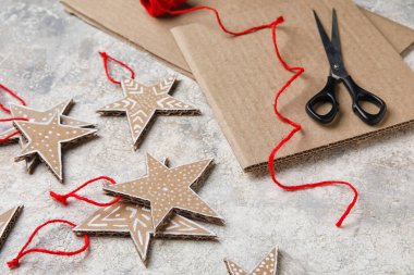 Arkaplanda iplik ve makas olan Noel karton yıldızları