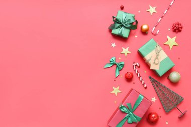 Kırmızı arka planda Noel dekoru olan hediye kutuları