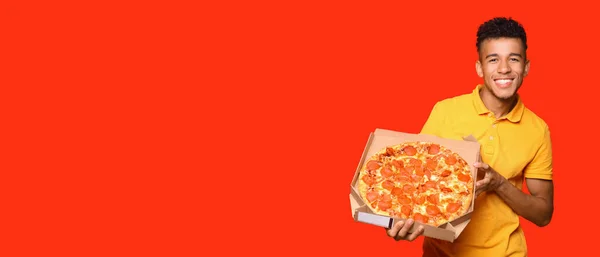 幸せなアフリカ系アメリカ人男性とともにおいしいピザ上の赤い背景とともにテキストのためのスペース — ストック写真