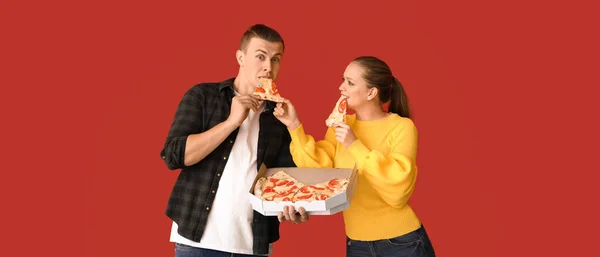 Young Couple Eating Tasty Pizza Red Background — Stock Photo, Image