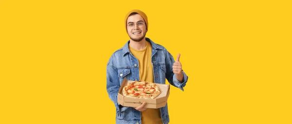 Knappe Jongeman Met Lekkere Pizza Met Duim Gele Achtergrond — Stockfoto