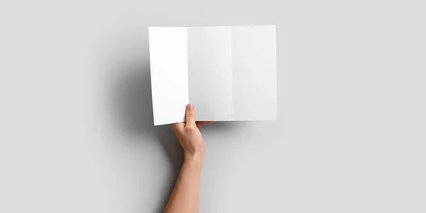 stock image Hand with blank brochure on light background