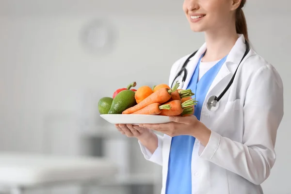診療所で野菜の皿を持つ女性医師 — ストック写真