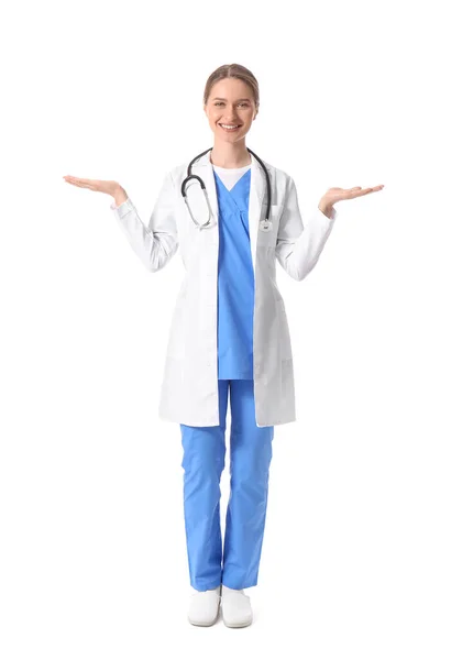 白い背景に何かを示す笑顔の女性医師 — ストック写真