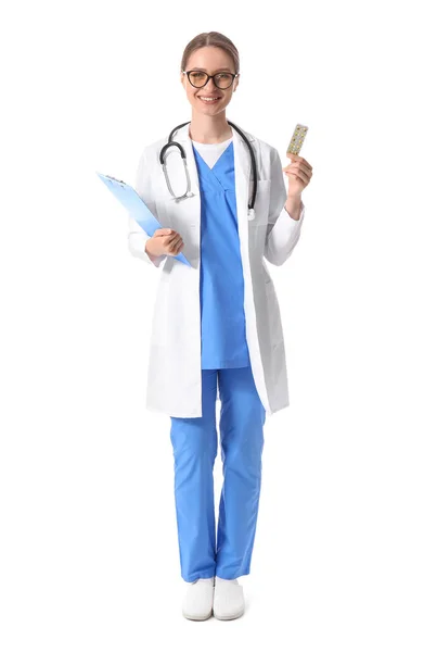 具有白色背景维生素和剪贴板的女医生 — 图库照片