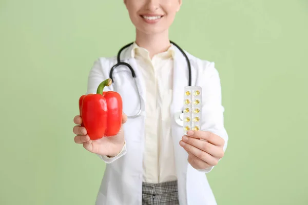 具有绿色背景维生素和甜椒的女医生 — 图库照片
