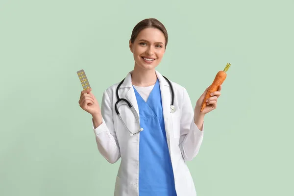 具有绿色背景维生素和胡萝卜的女医生 — 图库照片