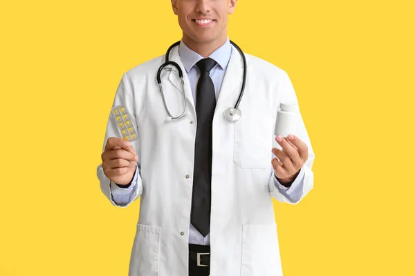 黄色の背景にビタミンと男性医師 — ストック写真