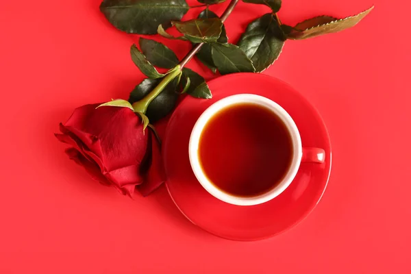 お茶と赤いバラの花のカップの色の背景 — ストック写真