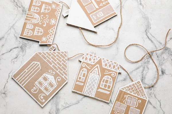 Christmas cardboard houses with rope on light background