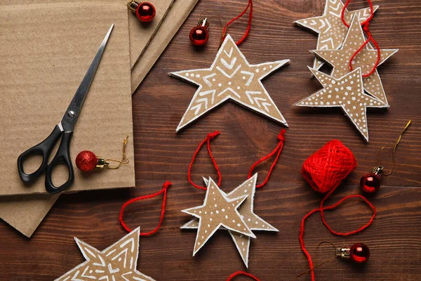 Pappsterne Mit Fäden Und Weihnachtskugeln Auf Dunklem Holzhintergrund — Stockfoto