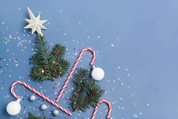 モミの枝 キャンディーの杖と色の背景に装飾で作られたクリスマスツリー クローズアップ — ストック写真
