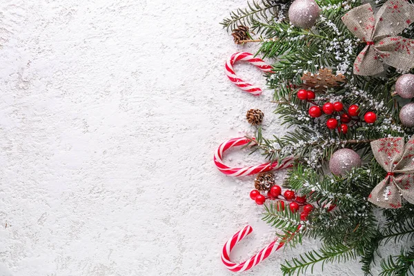 光の背景にモミの枝 キャンディーの杖とクリスマスの装飾と構成 — ストック写真