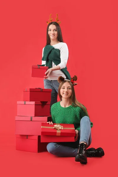 Jovens Mulheres Chifres Rena Com Presentes Natal Fundo Vermelho — Fotografia de Stock
