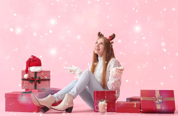 Mujer Joven Sentada Con Regalos Navidad Nieve Cayendo Sobre Fondo —  Fotos de Stock