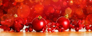 Masada kırmızı arka planda bulanık ışıklarla güzel Noel topları