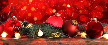 Bulanık ışıklara karşı güzel kırmızı Noel baloları ve köknar dalları