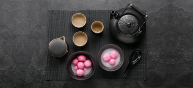 Bir kase tangyuan, koyu arkaplanda fincanlar ve çaydanlıklar. Dongzhi Festivali