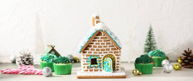 Tatlı zencefilli kek evi ve arka planda Noel süsü.