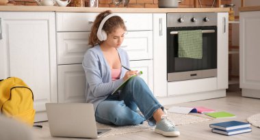 Mutfakta online çalışan kız öğrenci.