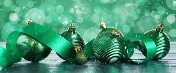 Krásné Vánoční Koule Stole Proti Zelenému Pozadí Rozmazanými Světly — Stock fotografie