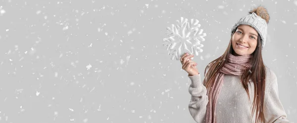 Χαμογελαστή Νεαρή Γυναίκα Χειμωνιάτικα Ρούχα Κρατώντας Μεγάλη Νιφάδα Χιονιού Γκρι — Φωτογραφία Αρχείου
