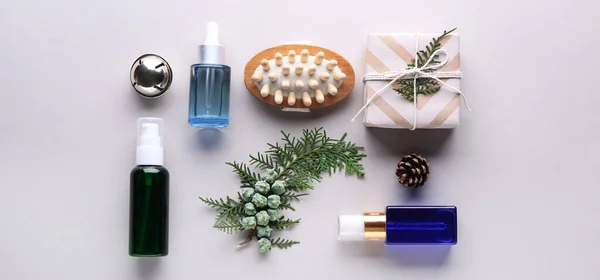 Christmas composition with cosmetic products for spa treatment on light background, top view