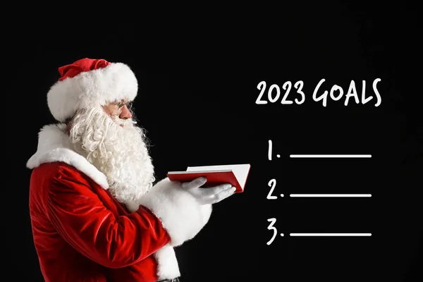 2023年圣诞老人 背景为黑色 有笔记本和空白待办事项清单 — 图库照片