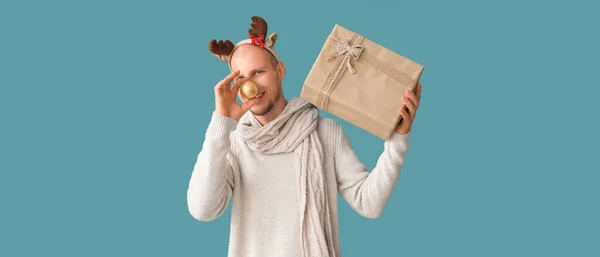 Αστείος Άνθρωπος Κέρατα Ελαφιού Και Χριστουγεννιάτικο Δώρο Γαλάζιο Φόντο — Φωτογραφία Αρχείου