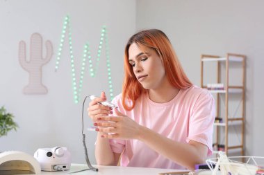 Manikür ustası, manikür makasıyla manikür masasında.