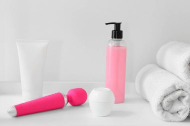 Vibratör ve banyo malzemeleri ışık duvarının yanındaki rafta.