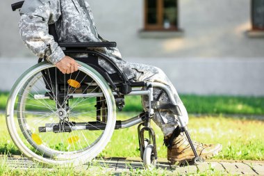 Dışarıda tekerlekli sandalyede genç bir asker var.