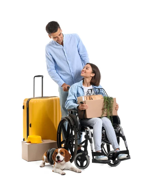 年轻男子 妻子坐在轮椅上 提着箱子 手提箱和狗 背景是白色的 — 图库照片