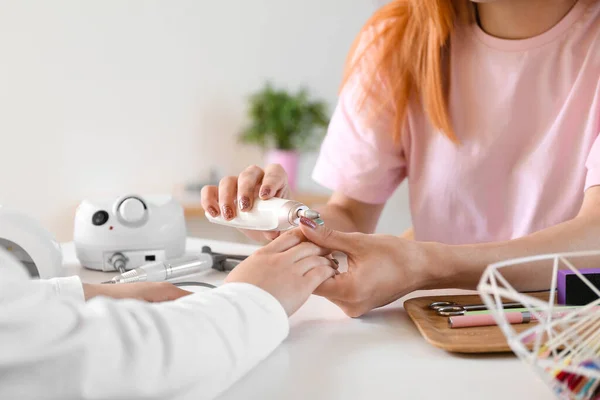 Stock image Transgender manicure master working with client at table in nail salon, closeup