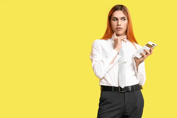 Nachdenkliche Transgender Sekretärin Mit Taschenrechner Auf Gelbem Hintergrund — Stockfoto