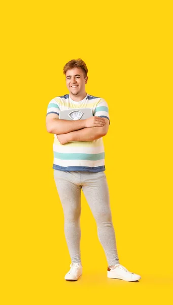 Jovem Homem Com Sobrepeso Com Escalas Fundo Amarelo — Fotografia de Stock