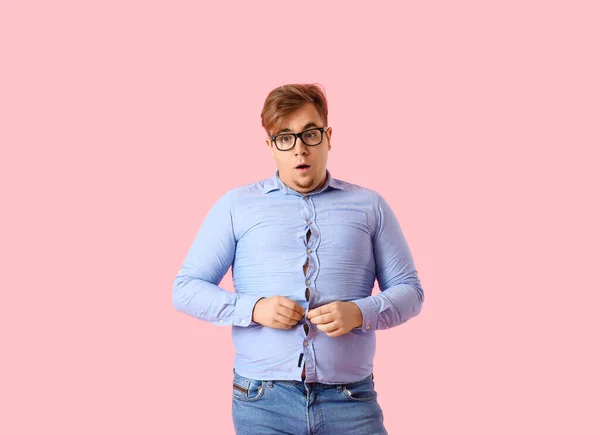 若いです太りすぎ男でタイトシャツ上のピンクの背景 — ストック写真