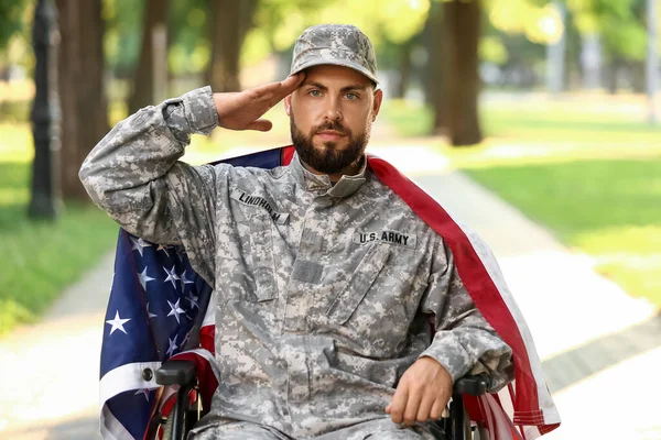 Młody Żołnierz Wózku Inwalidzkim Flagą Usa Salutującą Zewnątrz — Zdjęcie stockowe