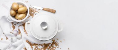 Beyaz zemin üzerinde patates, mercimek ve pişirme tenceresi.