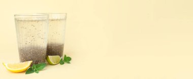 Chia tohumlu su bardakları, limon, kireç ve nane yaprakları bej arkaplan üzerinde metin için boşluk