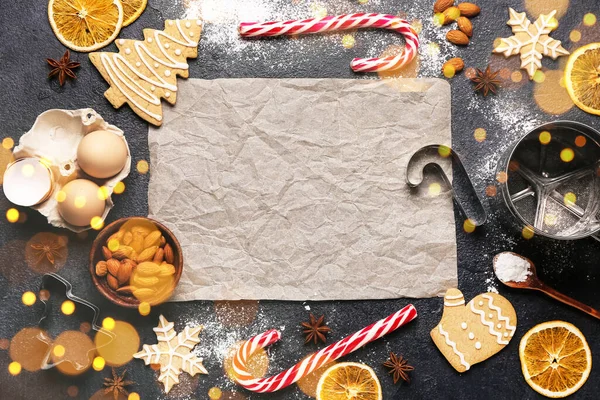 Composition with parchment, Christmas cookies and ingredients on dark background