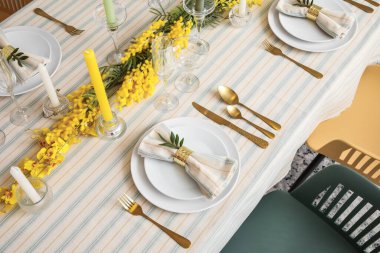 Çiçek dekoru ve mumlarla dolu bir ziyafet masası.