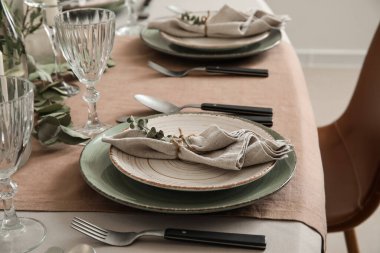 Servis masasında peçete ve okaliptüs dalı olan bir tabak.