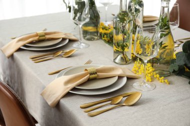 Yemek takımı, peçeteler ve servis edilen masada güzel bir çiçek dekoru.